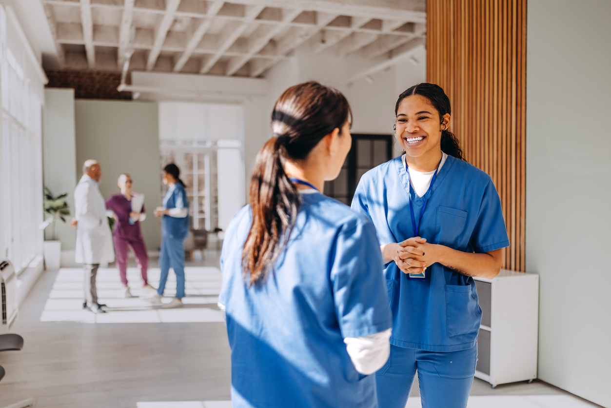Smiling nurses talking in a hallway of a medical facility